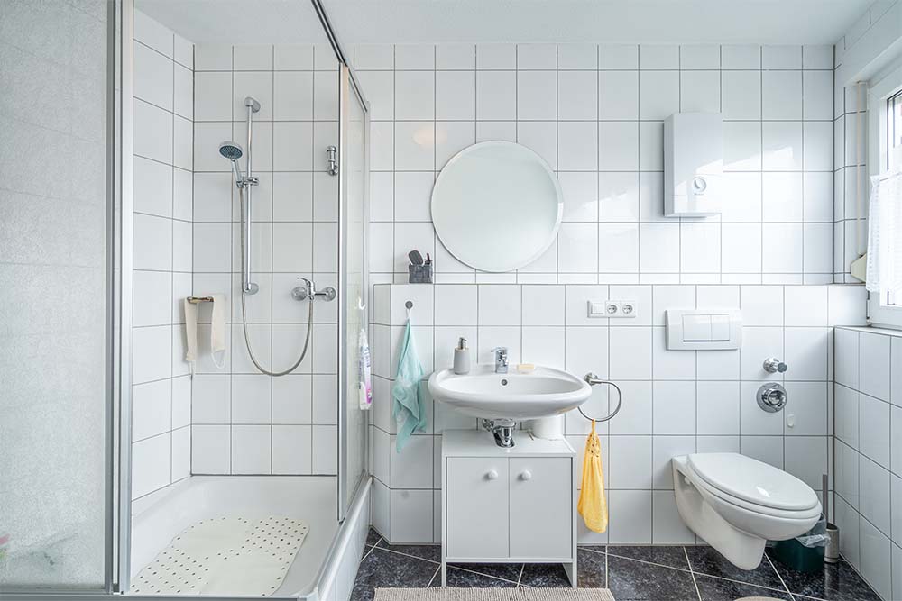 Weiß gefliestes Badezimmer- Ihr Immobilienmakler KRAN IMMO in Paderborn
